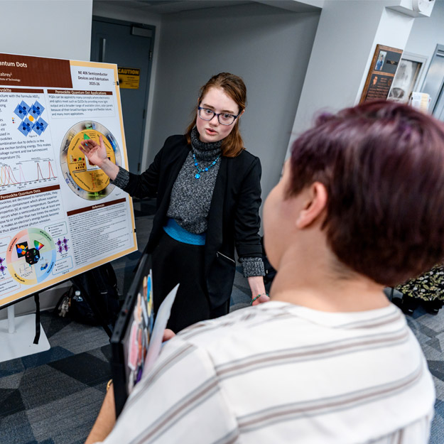 Students present posters about their semiconductor research.