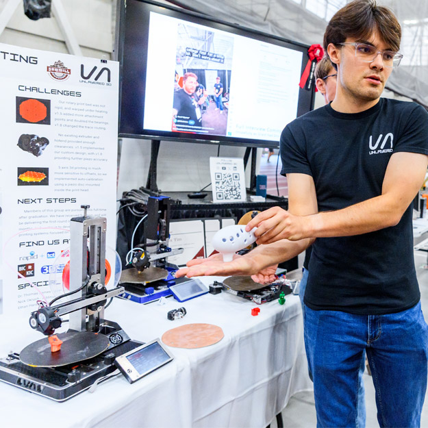 A student presents the multi-axis 3D printer at Rose Show.