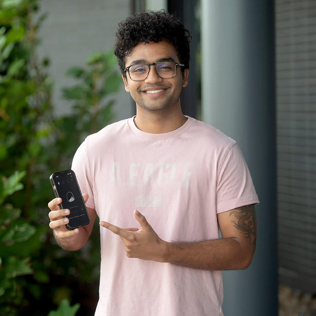 Vishrut Patwari, a 2025 computer science alumnus, points to his app on his phone.